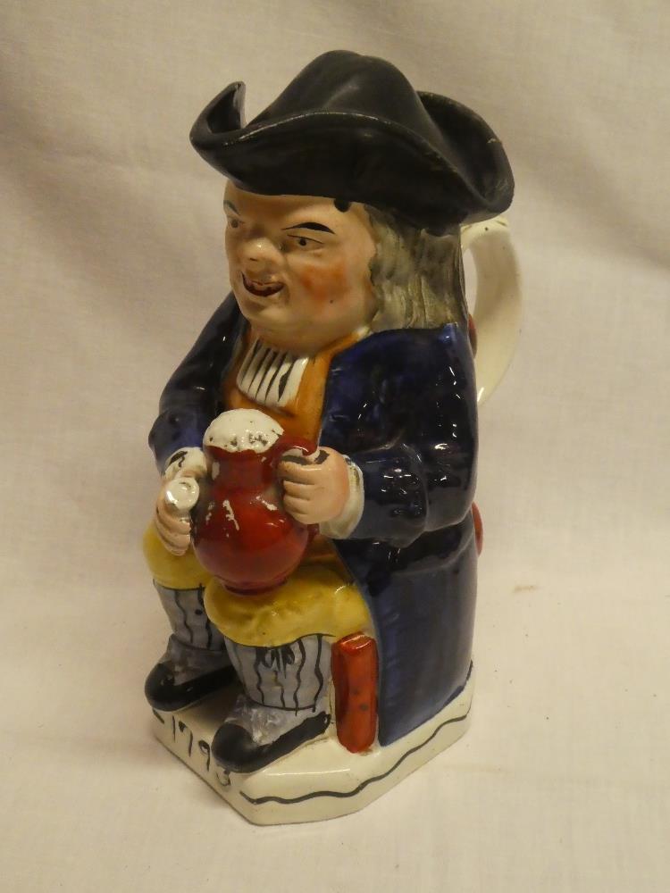 A 19th Century Staffordshire pottery traditional Toby jug depicting Toby wearing a tricorn hat and