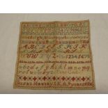 A Victorian square needlework sampler by Susan Hannay dated 1886 depicting alphabet,
