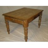An old polished pine rectangular kitchen/dining table with a drawer in one end on turned tapered