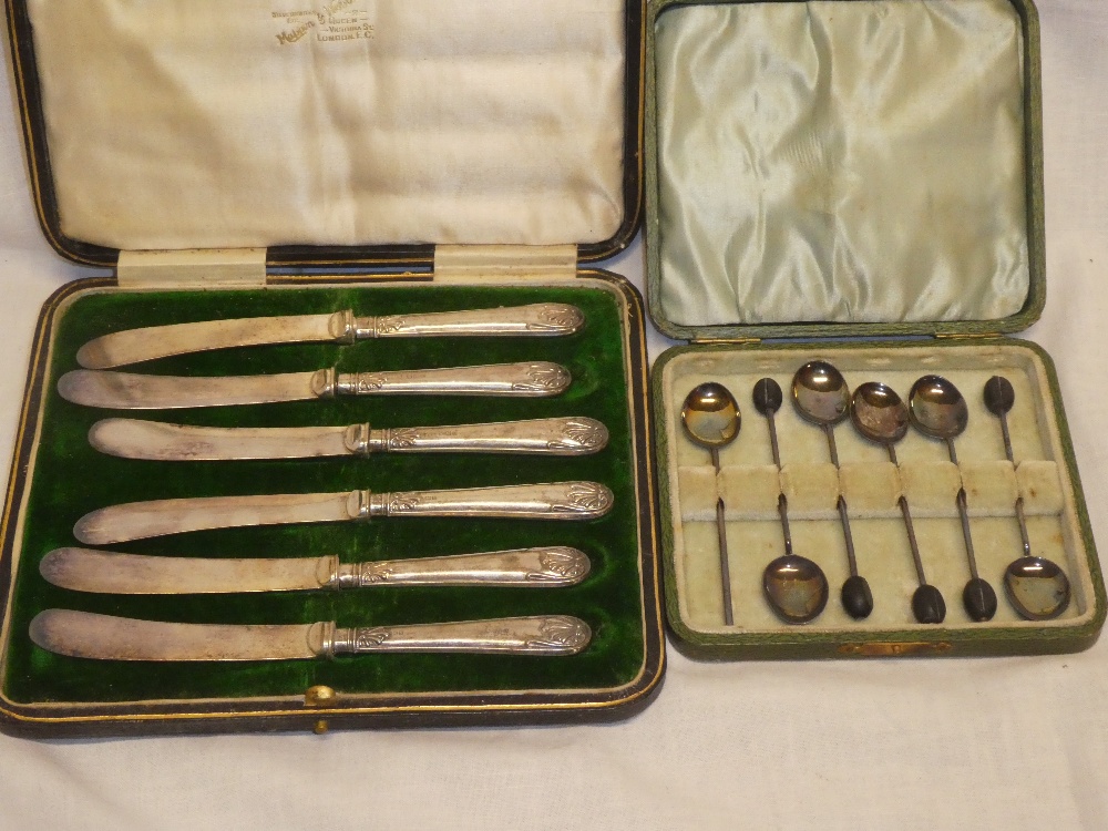 A set of six silver coffee spoons in velvet lined case and a set of six silver handled tea knives,