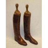 A pair of brown leather riding boots with fitted wooden trees