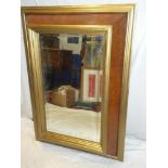 A bevelled rectangular cushion-framed mirror with polished walnut and gilt painted decoration 42" x