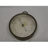 An old aneroid holosteric barometer with circular dial in brass circular case