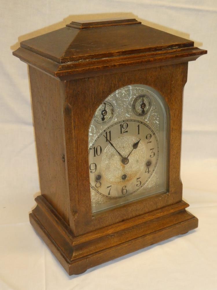 A good quality German bracket clock with silvered arched dial in polished oak rectangular case