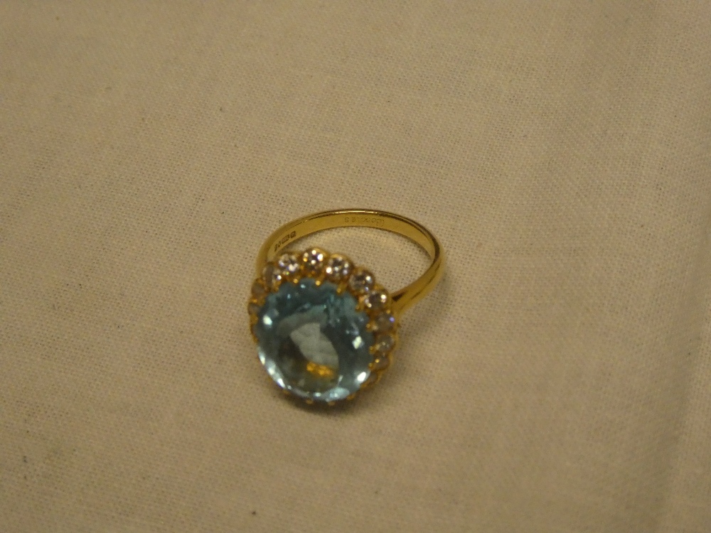 An 18ct gold dress ring set blue stone and diamond chips