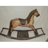 A modern Victorian-style wooden rocking horse with leather saddle,