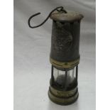 An old brass and painted metal bonnetted miner's lamp by Ackroyd and Best Limited
