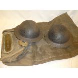 Two Second War British steel helmets and a brass mounted canvas soldier's kit bag named to G.