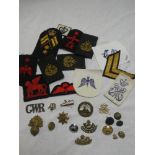 A selection of various military badges including a pair of Cornwall Light Infantry collar badges,