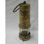 An old brass mining lamp numbered "272" with swing handle