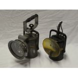 An old brass mounted painted metal carbide mining lamp with circular reflector and one other