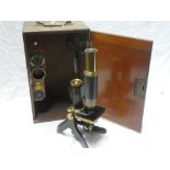 A brass and painted metal monocular microscope by Swift & Sons of London in fitted mahogany case