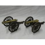 A pair of brass ornamental model cannons with 5" brass barrels on iron carriages