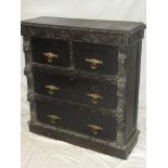 A late Victorian carved oak chest of two short and two long drawers with brass ring handles flanked