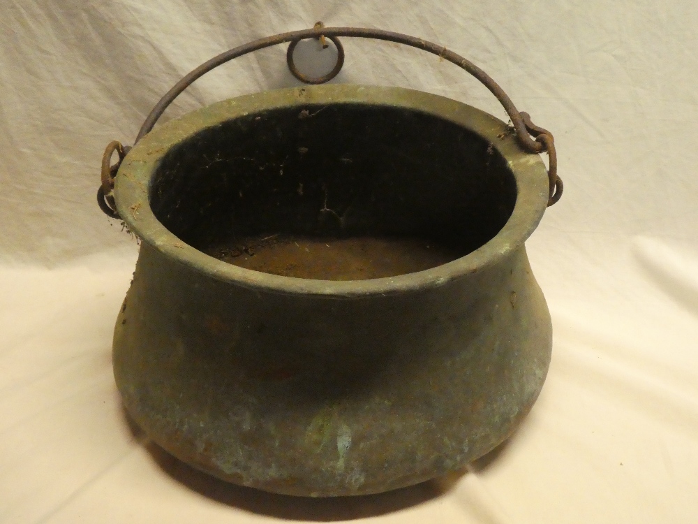 A 19th Century copper circular cauldron with iron swing handle,