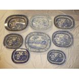 A 19th century pottery oval meat platter with figures on a river blue and white decoration,