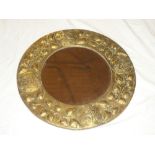 A bevelled circular wall mirror in embossed brass circular frame decorated with leaves 20½"