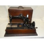 A vintage sewing machine by Wheeler & Wilson in polished stained wood case