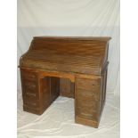 An Edwardian oak roll-top desk with tambour front and eight pedestal drawers