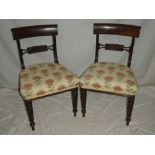 A set of four William IV mahogany dining chairs with rail-backs and upholstered seats on turned