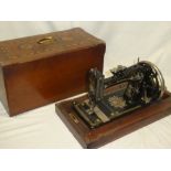 A vintage sewing machine "The Wanzer" in inlaid walnut case