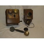 A brass mounted oak wall mounted telephone with twin bells and hand receiver and a wall mounted