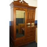 A Victorian carved walnut combination wardrobe by Maple & Co.