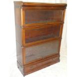 A Globe Wernicke mahogany three tier stacking bookcase with folding glazed fronts and base drawer