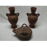 A pair of Eastern terracotta tapered vases with dragon decorated handles,