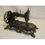 An old manual sewing machine with painted frame on scroll base