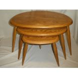 A nest of Ercol light elm "Pebble" tea tables on tapered legs