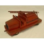 An old painted metal model fire engine with hinged rear compartment and swivelling ladder 14½" long