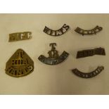 A selection of various brass shoulder titles including "T/RGA/Hants";
