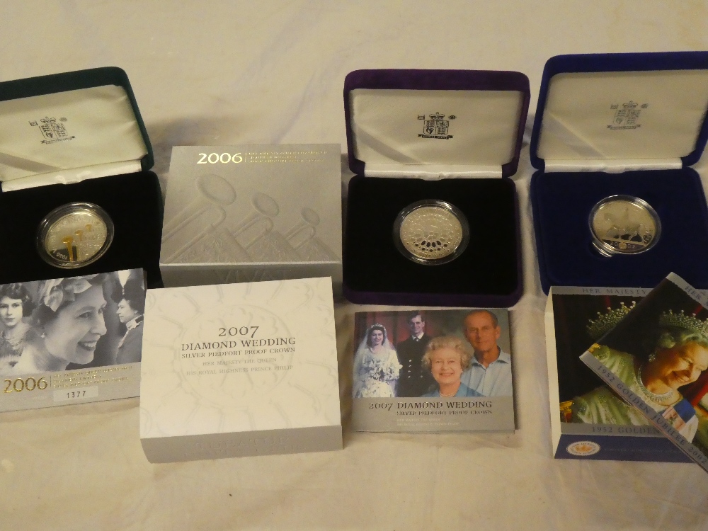 Three cased silver commemorative crowns with certificates including 2006 Queen's 80th Birthday,