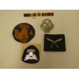 An original Chindit arm badge, Federation of Malaya Police cap badge,