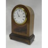An Edwardian mantel clock with enamelled circular dial in inlaid mahogany arched case