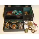 A leather jewellery box containing a quantity of various costume jewellery including brooches,