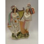 A Victorian Staffordshire pottery flat back figure of a male and female musician,