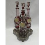 A set of Bohemian-style cut glass ruby tinted decanters and stoppers with vine leaf decoration on
