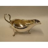 An Edward VII silver classical-shaped sauce boat with scroll handle on three hoof feet,