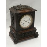 A Continental mantel clock by Japy Freres with circular enamelled dial in Black Forest-style carved