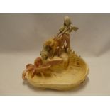 A Royal Dux-style pottery figure of a young boy with two dogs above a rockpool bowl,