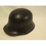 A Second War German black painted steel helmet with liner and chin strap