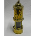 An old brass mining lamp by Thomas & Williams with gauze centre and swing handle