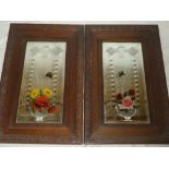 A pair of bevelled glass rectangular mirrors with floral decoration within carved oak frames,