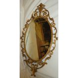 A good quality oval wall mirror in gilt metal scroll decorated frame 50" x 28"