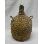 A 19th century green glass bottle flask with stringwork binding