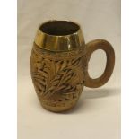 An unusual carved limewood pint size tankard with foliage decoration and brass mounted rim