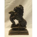 A Victorian cast iron doorstop in the form of a lion with shield,