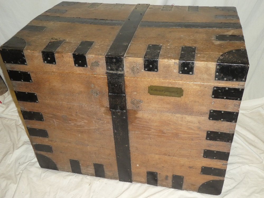 A 19th century metal-bound oak rectangular domed trunk with hinged lid and iron handles,